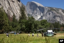 President Barack Obama, center, and first lady Michelle Obama follow their daughters to board the Marine One helicopter in a meadow to leave Yosemite National Park, on Sunday, June 19, 2016, after visiting the park to celebrate the 100th anniversary of th