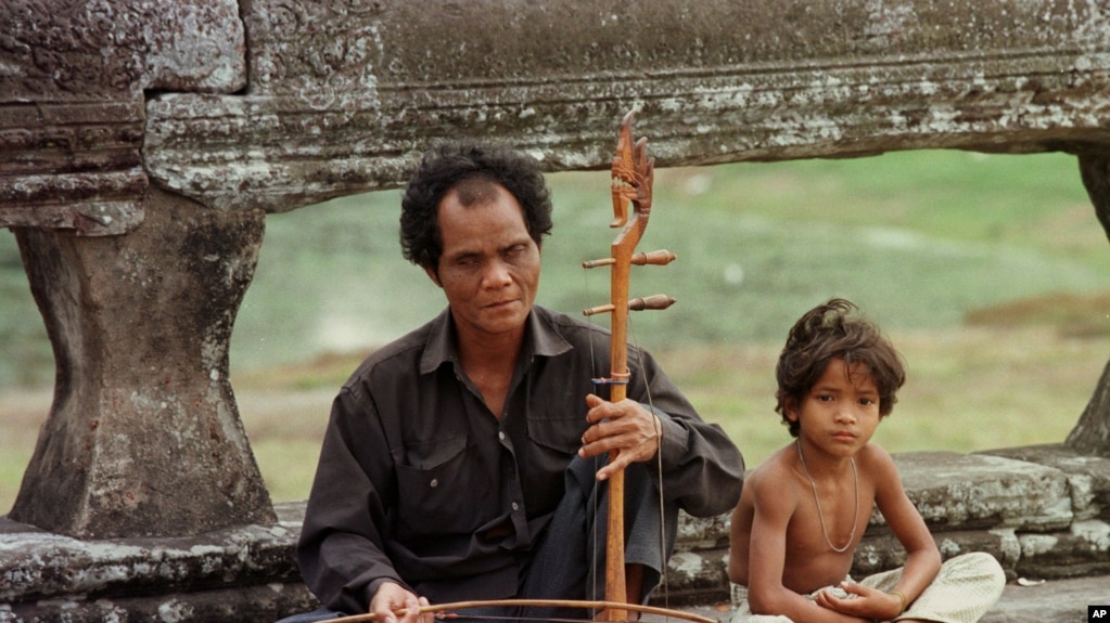 A blind musician plays his traditional Cambodian violin along the promenade at Angkor Wat in Siem Reap on Monday January 22,1996. (AP Photo/Richard Vogel)