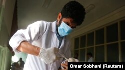 Seorang dokter merawat seorang pria yang terluka di sebuah rumah sakit setelah ledakan bom di sebuah rumah sakit militer di Kabul, Afghanistan, 9 Maret 2017. (Foto: REUTERS/Omar Sobhani)