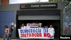 Partidarios de la oposición salen de una estación de metro con una pancarta que dice "democracia sí, dictadura no" durante una protesta en Caracas, el 31 de marzo de 2017. Foto: Reuters.