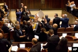 Israeli Arab members hold signs in protest as security pushes them out as U.S. Vice President Mike Pence speaks in Israel's parliament in Jerusalem, Jan. 22, 2018.