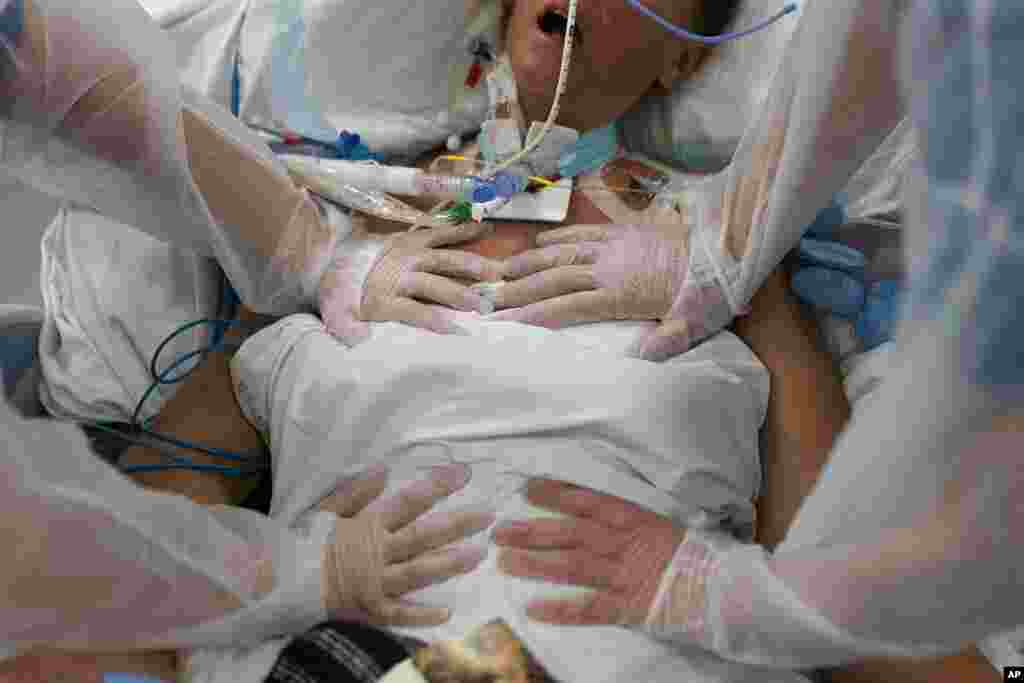 Nurses perform timed breathing exercises on a COVID-19 patient on a ventilator in the COVID-19 intensive care unit at the la Timone hospital in Marseille, southern France.