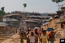 FILE - Rohingya refugees rebuild their makeshift houses, in preparation for the approaching monsoon season at the Kutupalong Rohingya refugee camp in Kutupalong, Bangladesh, Apr. 28, 2018.