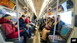 Personas con cubrebocas debido al coronavirus viajan en el metro de Londres el 28 de noviembre de 2021. (Foto AP/Alberto Pezzali)