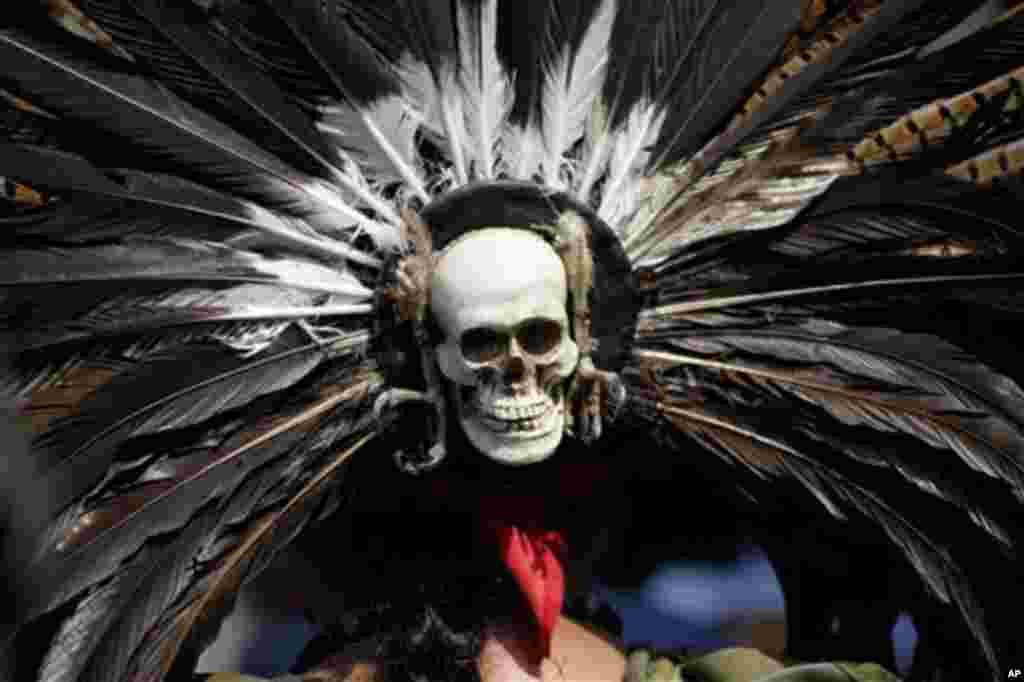 A mask in the likeness of a human skull adorns the back of a head piece worn by an Aztec dancer during a demonstration outside Mexico City's Legislative Assembly, Tuesday Nov. 8, 2011. The city legislature's Indigenous Commission is proposing a law that 