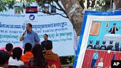 Khmer Rouge Tribunal spokesman Lars Olsen speaking to former members of the ultra-Maoist group in Anlong Veng, Cambodia at the home of Ta Mok, a former senior leader believed to have been responsible for many of the regime's worst atrocities. The poster o