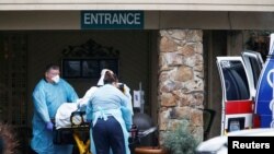 Tenaga medis memasukkan seorang pasien ke ambulans di Life Care Center of Kirkland, fasilitas perawatan jangka panjang terkait beberapa kasus virus corona di Kirkland, Washington, AS. 6 Maret 2020. (Foto: Reuters / Lindsey Wasson)