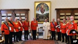 FILE - Pope Francis, flanked at left by Grand Master of the Knights of Malta Matthew Festing, stands during a family photo at the Vatican, Thursday, June 23, 2016