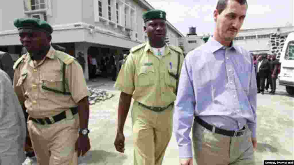 Azim Aghajani, right, an Iranian citizen, charged with orchestrating an illegal arms shipment into Nigeria from Iran is led away, after sentencing, at the Federal High Court, in Lagos, Monday, May 13, 2013.