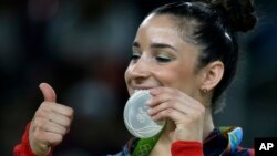 FILE - United States' Aly Raisman displays her silver medal for floor during the artistic gymnastics women's apparatus final at the 2016 Summer Olympics in Rio de Janeiro, Brazil, Tuesday, Aug. 16, 2016.