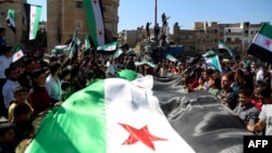 Syrian protesters, wearing the colors of opposition, attend an anti-government demonstration in the rebel-held northern Syrian city of Idlib, Sept. 28, 2018.