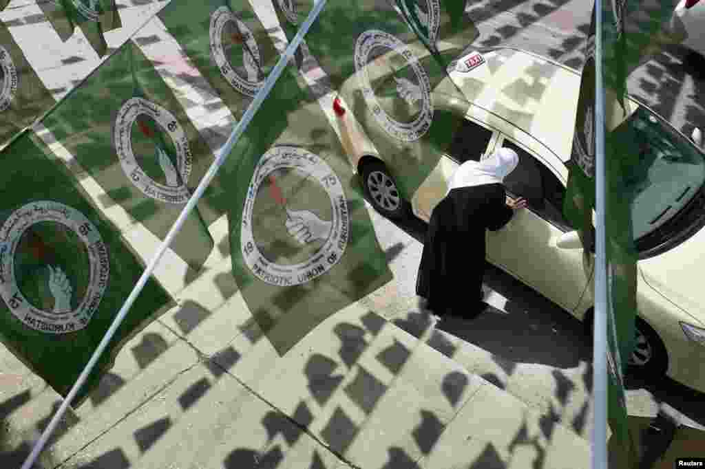 A woman hails a taxi while standing under Patriotic Union of Kurdistan (PUK) logos before Iraq's parliamentary elections in Sulaimaniya April 28, 2014. Picture taken April 28, 2014. To match IRAQ-ELECTION/KURDS REUTERS/Jacob Russell (IRAQ - Ta