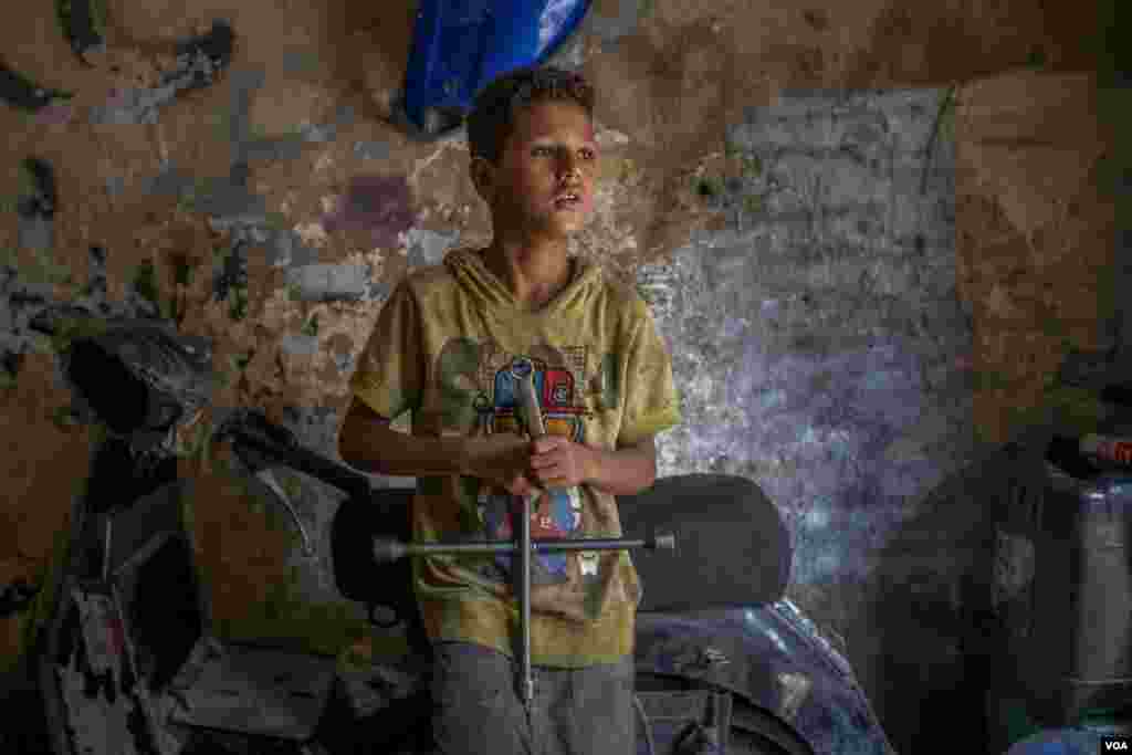 Mostafa, 11, left school three years ago and now works at a local mechanic’s shop six days a week, from 11 a.m. to midnight, to help support his large family. His dream is to one day own a smartphone, Cairo, Aug. 9, 2021. (Hamada Elrasam/VOA)