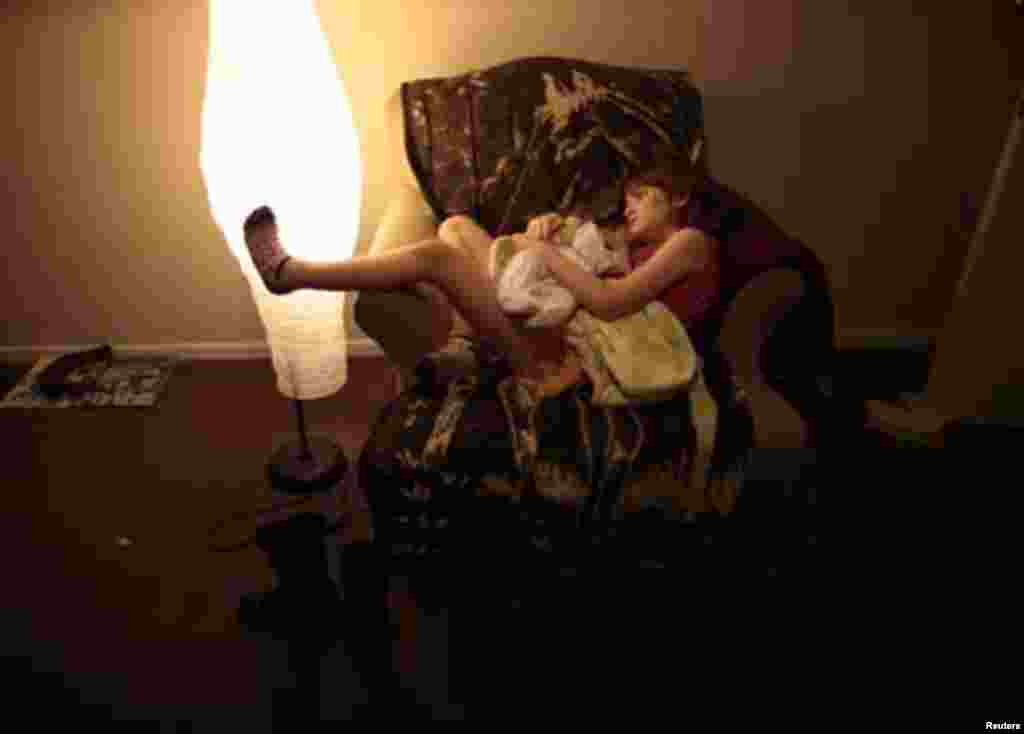 Lilly Earp, 8, hugs her five-week-old sister Emily in their apartment at Hope Gardens Family Center, a shelter for homeless women and children, run by Union Rescue Mission on 77 acres (0.31 square km) of countryside away from Skid Row, on the outskirts of