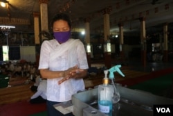 ស្រ្តី​ម្នាក់​កំពុង​លាង​ដៃ​នឹង​អាល់​កុល អំឡុងពេលប្រារព្ធ​ពិធី​បុណ្យ​ចូល​ឆ្នាំ​ខ្មែរ​ថ្ងៃទី​២ នៅ​វត្តថាន់​ រាជធានី​ភ្នំពេញ នៅ​ថ្ងៃ​ទី​១៤ ខែមេសា ឆ្នាំ​២០២០។ (កាន់ វិច្ឆិកា/VOA)