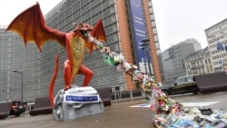 A statue depicting a plastic-throwing dragon is set up in front of the European Commission, during an action by NGO alliance Rethink Plastic to demand an end of the use of disposable plastic, in Brussels on November 26, 2018. (Photo by AFP)