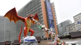 A statue depicting a plastic-throwing dragon is set up in front of the European Commission, during an action by NGO alliance Rethink Plastic to demand an end of the use of disposable plastic, in Brussels on November 26, 2018. (Photo by AFP)