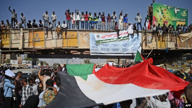 Sudanese protesters wave a national flag during a "million-strong" march outside the army headquarters in the capital Khartoum April 25, 2019.