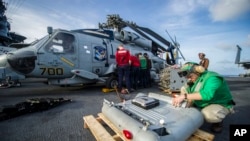 Para awak kapal induk AS menyiapkan helikopter Sea Hawk di atas kapal induk AS USS George Washington untuk operasi bantuan di Filipina (13/11). 