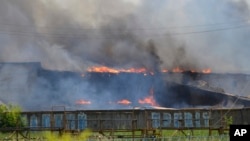 Asap hitam mengepul dari pabrik furniture yang terbakar pasca serangan mortir pasukan Ukraina di Slovyansk, Ukraina timur (8/6).
