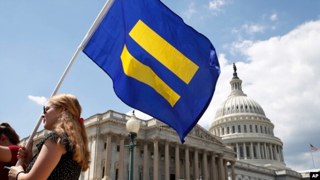 一名LGBT权利支持者举着“平等旗”参加民主党众议员乔·肯尼迪的集会，抗议特朗普总统不许跨性别者服役的禁令。(2017年7月26日）