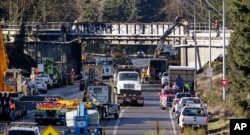 Vehicles fill the highway at the scene of Monday's Amtrak train crash onto Interstate 5 from the railroad bridge above, Dec. 20, 2017, in DuPont, Wash.