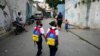 Unas niñas caminan a la escuela el primer día de regreso a la escuela presencial desde el inicio de las restricciones por la pandemia de COVID-19 en Caracas. Octubre 25, 2021.