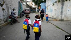 Unas niñas caminan a la escuela el primer día de regreso a la escuela presencial desde el inicio de las restricciones por la pandemia de COVID-19 en Caracas. Octubre 25, 2021.