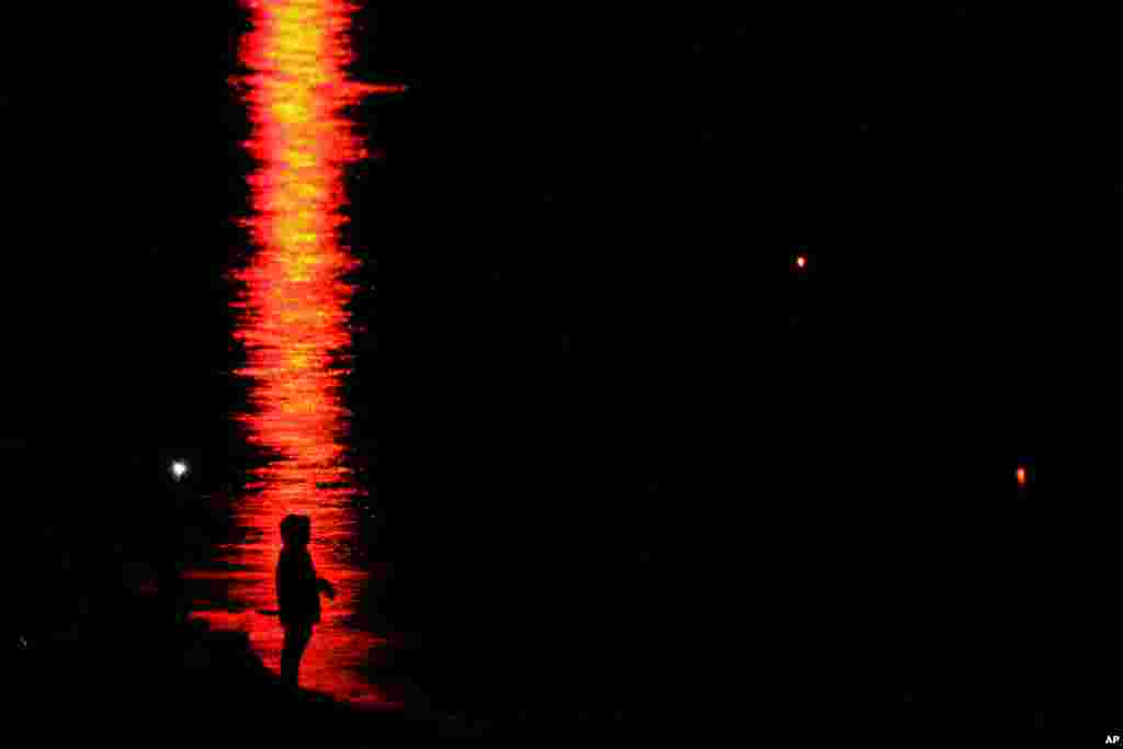 A person is silhouetted on the water while fishing at Clinton Reservoir, April 26, 2020, near Lawrence, Kansas.