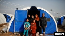 Displaced Iraqi Gorha Mahmoud (left), 40, poses for a photograph with family at Hammam al-Alil camp south of Mosul, Iraq, March 29, 2017.