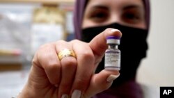 Una voluntaria de una unidad de mujeres de un servicio de emergencias de Israel muestra un vial de la vacuna contra el COVID-19 desarrollada por Pfizer-BioNTech el 11 de enero de 2022. 