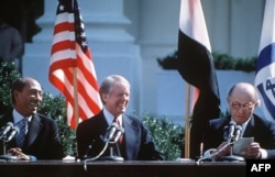 Egyptian President Anwar al-Sadat, left, and US President Jimmy Carter laugh during Israeli Premier Menachem Begin' speech, before signing the Israel-Egypt Peace Agreement on Sept. 17, 1978, on the north lawn of the White House, Washington DC.