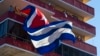 FILE - People watch a concert given by Puerto Rico's Olga Tanon, from a building flying a Cuban flag in Havana, Cuba, Saturday, Dec. 12, 2015.