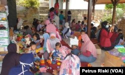 Anak-anak korban banjir di Batu, Jawa Timur, bermain di posko kesehatan dan psikososial yang didirikan oleh komunitas ALIT Indonesia dan Kalingga, pada 12 November 2021. (Foto: VOA/Petrus Riski)