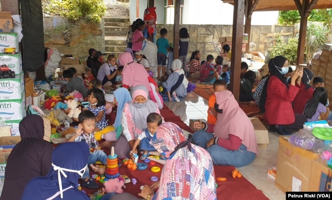 Anak-anak korban banjir di Batu, Jawa Timur, bermain di posko kesehatan dan psikososial yang didirikan oleh komunitas ALIT Indonesia dan Kalingga, pada 12 November 2021. (Foto: VOA/Petrus Riski)