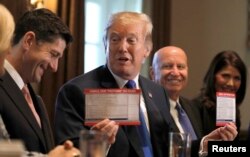 FILE - U.S. President Donald Trump holds sample tax forms as he promotes a newly unveiled Republican tax plan with House Republican leaders in the Cabinet Room of the White House in Washington, Nov. 2, 2017.