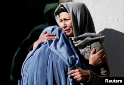 Afghan women mourn inside a hospital compound after a suicide attack in Kabul, Afghanistan.