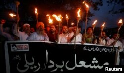 FILE - Protesters condemn the killing of Abdul Wali Khan University student Mashal Khan, after he was accused of blasphemy, during a protest in Peshawar, Pakistan, April 20, 2017. The banner reads, "We are all Mashal's Brothers."