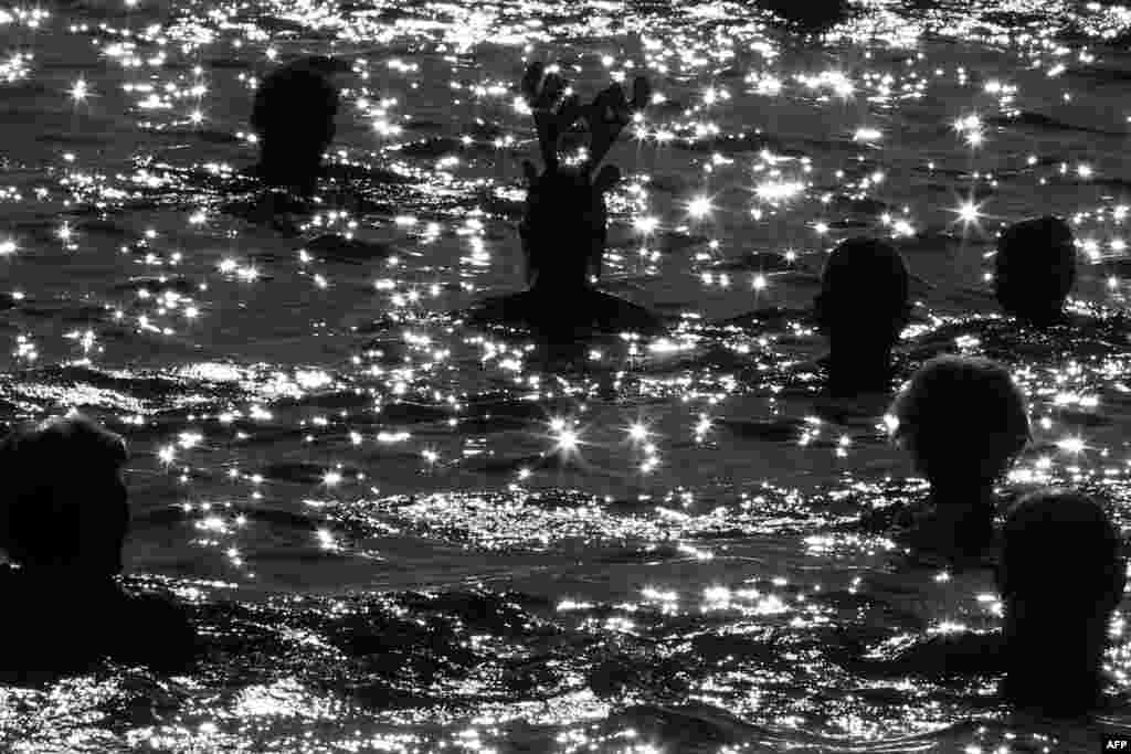 People swim in the Mediterranean Sea during the traditional Christmas bath in the French Riviera city of Nice, southeastern France.