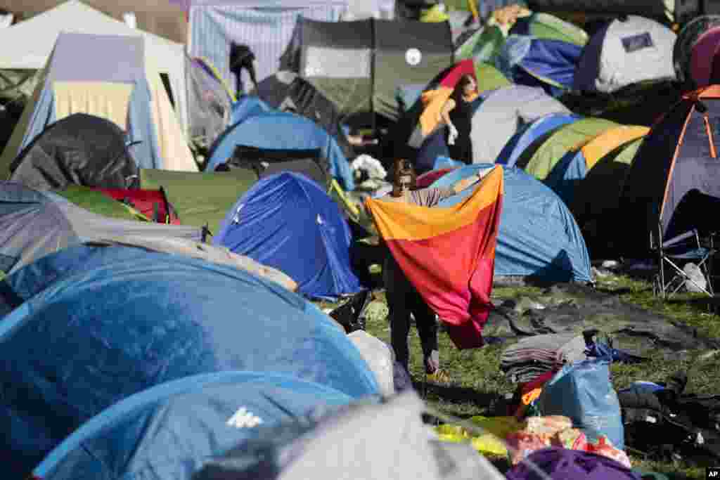 Volunteers clean a makeshift camp after hundreds of refugees were allowed to cross into Slovenia at the border station near Obretzje.