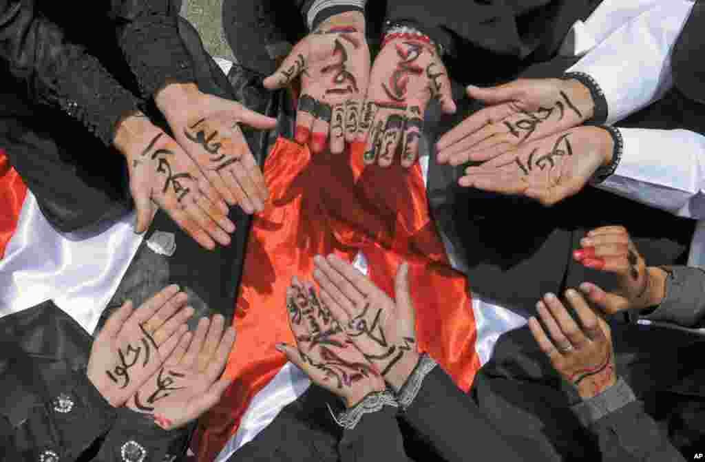 July 17, 2011: Female anti-government protestors display their hands with Arabic markings telling President President Ali Abdullah Saleh and his supporters to step down, during a demonstration in Sanaa.