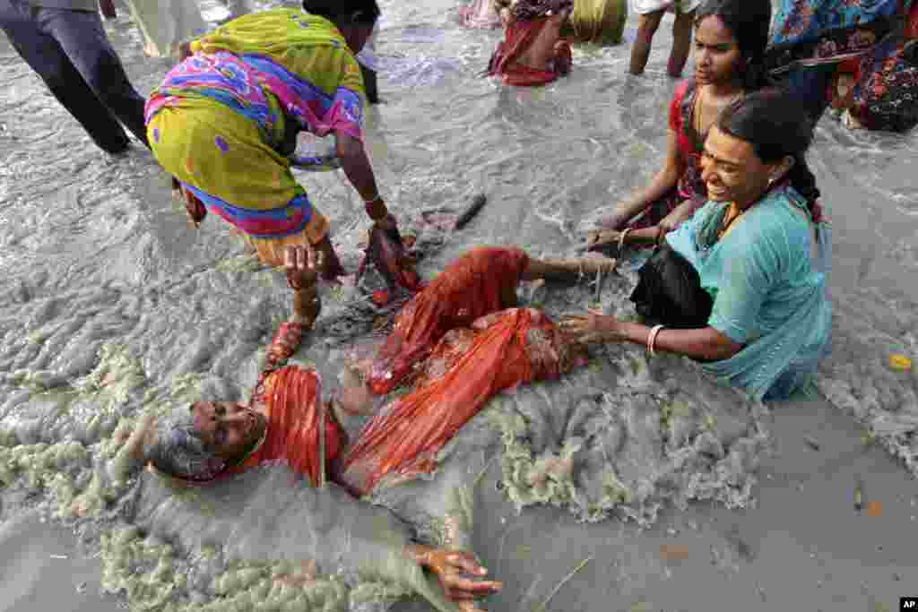  Seorang perempuan lansia ikut menceburkan diri dalam upacara di Sungai Ganga, India hari Senin (14/1). 