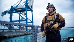 A security forces member stands guard aboard the Norwegian frigate Helge Ingstad, in Limassol, Cyprus, Dec. 28, 2013.