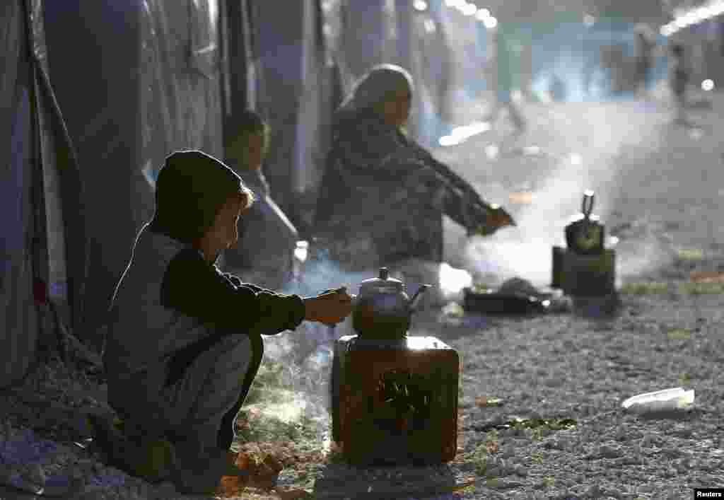 Pengungsi Kurdi mempersiapkan minum teh di kamp pengungsi&nbsp;Suruc, Turki. 