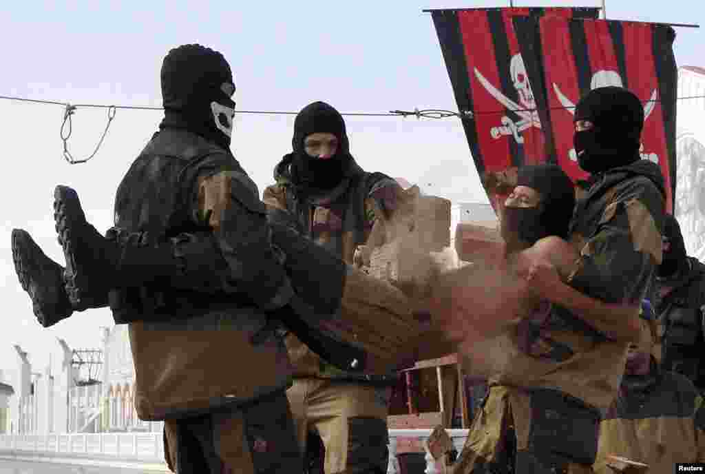 A member of the Pokrov youth military-patriotic club crushes a pile of bricks with a hammer on the stomach of a comrade as they demostrate their skills at Siberian Venice Park outside the Siberian town of Sosnovoborsk, Russia, Sept. 6, 2015.