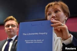 Marina Litvinenko, (R) widow of murdered ex-KGB agent Alexander Litvinenko, poses with a copy of The Litvinenko Inquiry Report with her son Anatoly (L) during a news conference in London, Britain, Jan. 21, 2016.