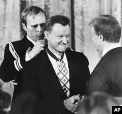 President Carter shakes hands with his national security adviser, Zbigniew Brzezinski, as he presents Brzezinski with the Medal of Freedom at a White House ceremony, Jan. 17, 1981, in Washington.