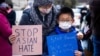 Melissa Min (kiri) dan putranya James melakukan aksi solidaritas dengan komunitas Asia-Amerika setelah meningkatnya serangan terhadap komunitas tersebut sejak awal pandemi virus corona setahun yang lalu, di Philadelphia, Pennsylvania, AS, 17 Maret 2021. (