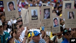 FILE - Demonstrators hold up posters with images of Venezuelans who were killed in the past two weeks during the recent unrest, at a rally with human rights activists in Caracas, Venezuela, Feb. 28, 2014.