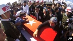 Fehime Aydemir (R), the mother of Turkish officer Metin Aydemir, cries over his coffin during funeral services in his hometown of Erzurum, Turkey, Aug. 19, 2015. Aydemir was one of the three officers killed Tuesday in an operation against Kurdish PKK rebels.